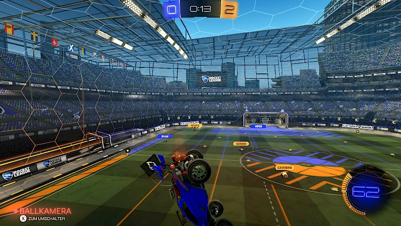 Ein Screenshot von Rocket League. In der erhöhten Perspektive lassen sich die blauen und orangenen Markierungen auf dem Spielfeld gut erkennen.