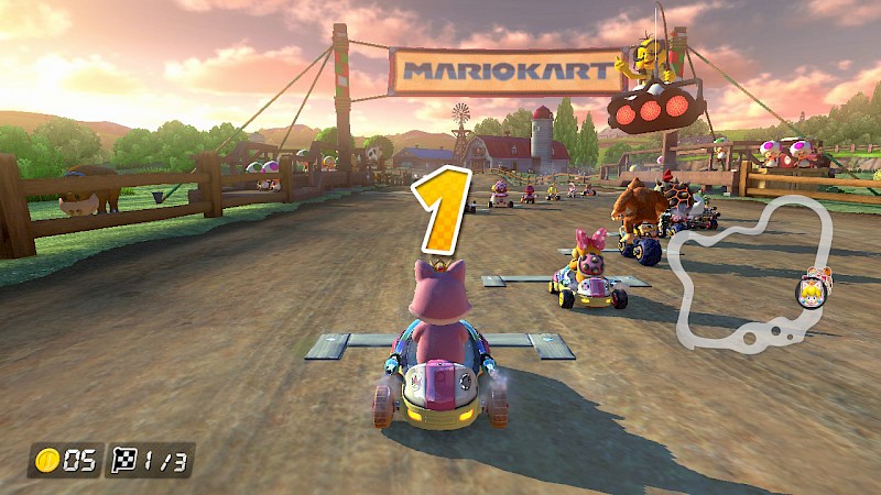 Ein Screenshot von Mario Kart. Im Hintergrund zeigt er eine Kuhwieseim Vordergrund befindet sich ein Fahrzeug mit dem Rücken zur Kamera. Außerdem sieht man einige Gegner:innen ebenfalls in der Startposition. Über dem Fahrzeug steht in gelbe eins.