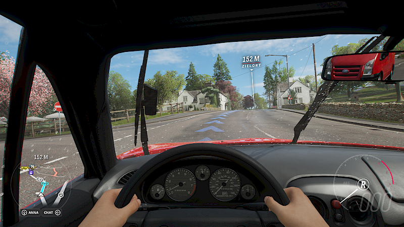 Die Perspektive aus dem Cockpit. Die Hände am Lenkrad und der Rückspiegel sind zu sehen.