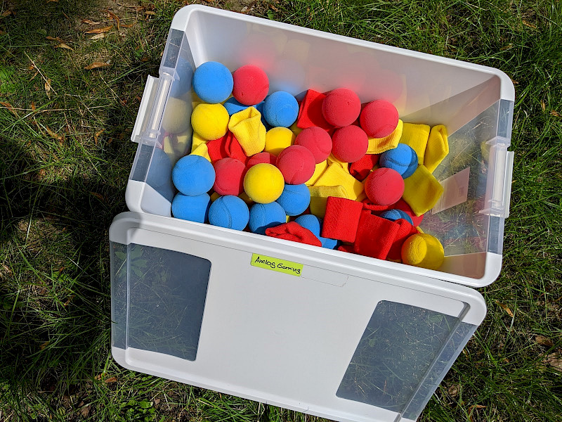 Das Bild zeigt eine Kiste mit verschiedenfarbigen Bällen.
